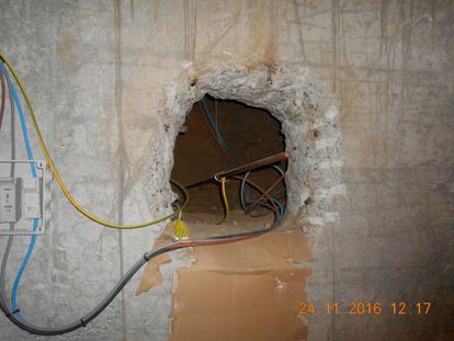 Agujero en el muro de carga de un edificio en Granada, realizado para pasar el cableado de un narcopiso.