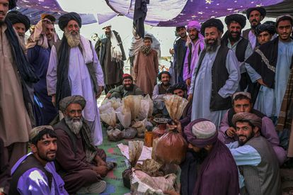 -- AFP PICTURES OF THE YEAR 2021 --

In this picture taken on September 24, 2021, men gather around bags containing heroin and hashish as they negotiate and check quality at a drug market on the outskirts of Kandahar. - While their country's economy teeters on the brink of collapse, vendors at an opium market in southern Afghanistan say prices for their goods have skyrocketed since the Taliban takeover. (Photo by Bulent KILIC / AFP) / AFP PICTURES OF THE YEAR 2021
